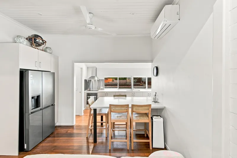 Dining table with stools, fridge/freezer and a view through to the kitchen