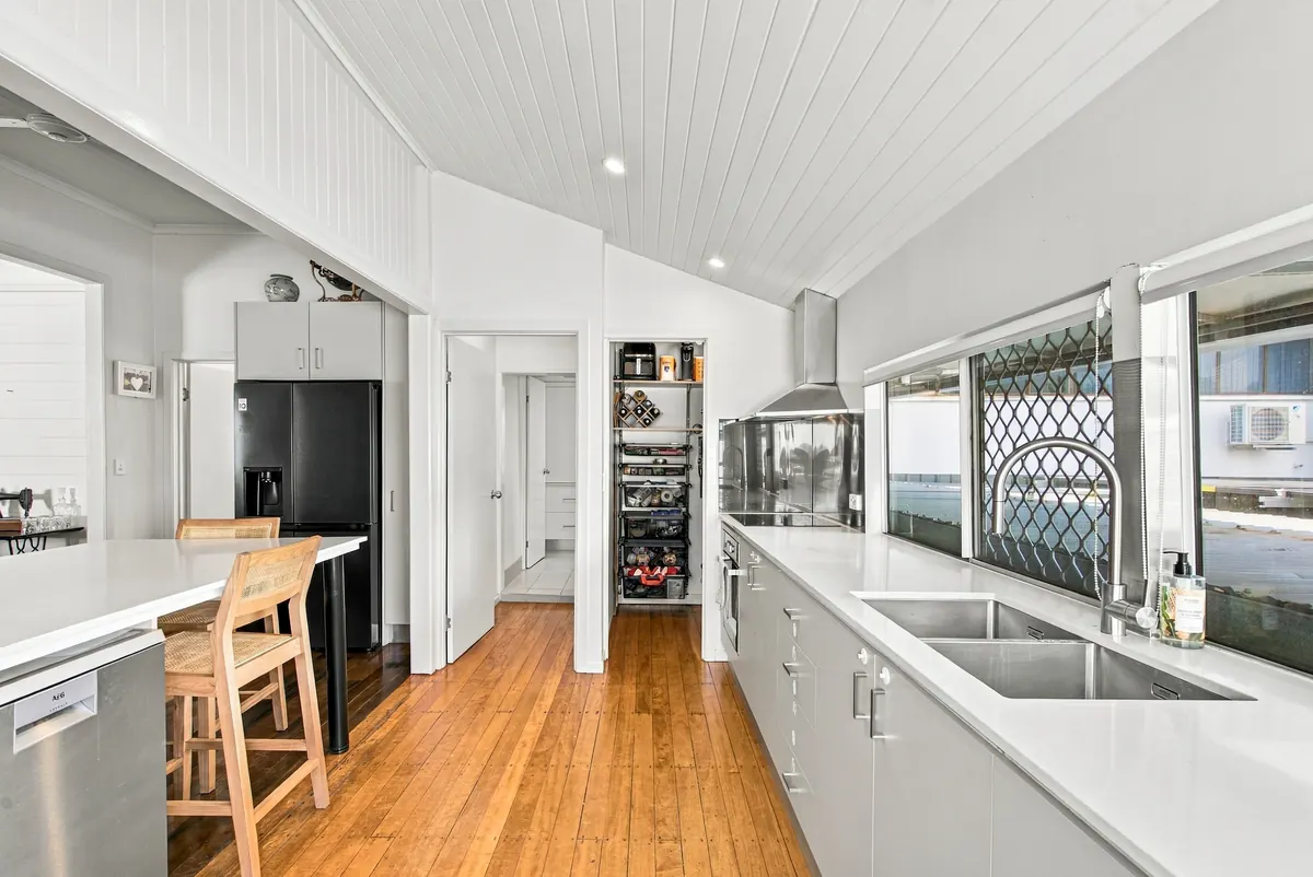 Kitchen with stone benchtops, double sink, walk-in pantry and polished timber floors